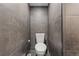 Modern bathroom featuring gray tiles, a white toilet, and black and white floors at 19792 E Bates Dr, Aurora, CO 80013
