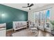 Bedroom with a white crib, a chair, a rug and large windows at 19792 E Bates Dr, Aurora, CO 80013