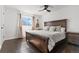 Primary bedroom with a wood bed frame, wood floors, a ceiling fan, and a view of the outside at 19792 E Bates Dr, Aurora, CO 80013