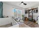 Bedroom with a white crib, a chair, a rug, large windows, and a clothing rack at 19792 E Bates Dr, Aurora, CO 80013