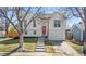 Charming two-story home with a white exterior, red door, and landscaped front yard at 19792 E Bates Dr, Aurora, CO 80013