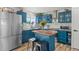 Stylish kitchen featuring vibrant blue cabinets, butcher block island, and stainless steel appliances at 19792 E Bates Dr, Aurora, CO 80013