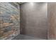 Modern shower with gray, black, and stone tile at 19792 E Bates Dr, Aurora, CO 80013