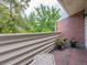 Private balcony with brick flooring, privacy wall, and views of mature trees at 2552 E Alameda Ave # 16, Denver, CO 80209