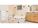Clean bathroom with a soaking tub, tile flooring, and natural wood cabinets at 2552 E Alameda Ave # 16, Denver, CO 80209