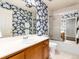 Full bathroom with blue wallpaper, shower-tub combo, and wood vanity at 2552 E Alameda Ave # 16, Denver, CO 80209