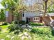 Charming brick home with well-manicured lawn, mature trees, and stone walkway leading to the front door at 2552 E Alameda Ave # 16, Denver, CO 80209