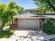 Two-car garage with concrete driveway and partial view of home exterior, showcasing a well-maintained property at 2552 E Alameda Ave # 16, Denver, CO 80209