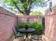Cozy private patio enclosed by brick walls, offering a serene outdoor retreat with a small table and peaceful ambiance at 2552 E Alameda Ave # 16, Denver, CO 80209