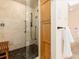Walk-in shower with dark tile flooring, wood bench, and glass door at 2552 E Alameda Ave # 16, Denver, CO 80209