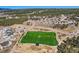 An aerial view of the neighborhood, surrounding trees, and community soccer field at 668 Sage Forest Ln, Monument, CO 80132