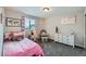 Cozy bedroom with pink accents, a comfortable bed, and natural light from the window at 668 Sage Forest Ln, Monument, CO 80132