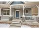 Inviting front porch featuring a cozy seating area, stone pillars, and decorative string lights at 668 Sage Forest Ln, Monument, CO 80132