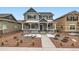Charming two-story home with gray stucco, white trim, covered porch, and beautifully landscaped front yard at 668 Sage Forest Ln, Monument, CO 80132
