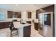 Well-lit kitchen with stainless steel appliances, dark cabinetry, and a large center island at 668 Sage Forest Ln, Monument, CO 80132