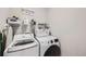 Functional laundry room with modern washer and dryer, shelving, and ample storage space at 668 Sage Forest Ln, Monument, CO 80132