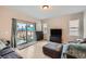 Cozy living room with a sliding glass door, neutral walls, and light hardwood flooring at 668 Sage Forest Ln, Monument, CO 80132