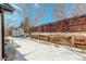 Snowy backyard with wooden fence, shed, and retaining wall at 4723 S Pagosa Way, Aurora, CO 80015