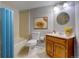 A quaint full bathroom with a shower/tub combination, decorative art, and wooden vanity at 4723 S Pagosa Way, Aurora, CO 80015