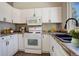 Well-equipped kitchen with white cabinets and granite countertops at 4723 S Pagosa Way, Aurora, CO 80015