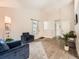 Spacious living room with vaulted ceilings, hardwood floors, two armchairs, and a plant next to the entry doors at 4723 S Pagosa Way, Aurora, CO 80015