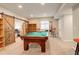Finished basement with a pool table, barn doors, and comfortable seating, perfect for relaxation and entertainment at 6630 S Coolidge Ct, Aurora, CO 80016