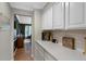 View of a butlers pantry with white cabinets and quartz countertops and hardwood floors at 7027 Chestnut Hill St, Highlands Ranch, CO 80130