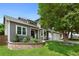 View of home featuring attached three-car garage and lush landscaping at 7027 Chestnut Hill St, Highlands Ranch, CO 80130