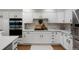 Modern kitchen with white cabinets, stainless steel appliances, and granite countertops at 7027 Chestnut Hill St, Highlands Ranch, CO 80130