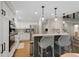 Modern kitchen with white cabinets, stainless steel appliances, hardwood floors, and island seating at 7027 Chestnut Hill St, Highlands Ranch, CO 80130