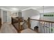 Open upstairs hallway with wooden railing and view of the entry way at 7027 Chestnut Hill St, Highlands Ranch, CO 80130