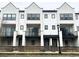 Exterior of a townhome with a balcony, a wooden fence, and a green lawn at 8311 Parkland St, Broomfield, CO 80021