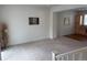 Bright living room with neutral carpet, a decorative painting, and a seamless transition to the kitchen area at 8311 Parkland St, Broomfield, CO 80021