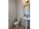 Clean powder room featuring a pedestal sink, toilet, and neutral tile flooring at 8311 Parkland St, Broomfield, CO 80021