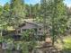 An aerial view of the home showing its position surrounded by mature trees and rocky terrain at 28251 Shadow Mountain Dr, Conifer, CO 80433