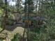 Backyard with patio, wooden swing, stone pathway, and surrounded by lush trees at 28251 Shadow Mountain Dr, Conifer, CO 80433
