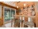 Cozy bar area with wood paneling, shelving stocked with drinks, and comfortable seating at 28251 Shadow Mountain Dr, Conifer, CO 80433