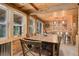 Rustic dining area features a wooden table and chairs, with views of the outdoors at 28251 Shadow Mountain Dr, Conifer, CO 80433