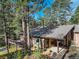 Charming home exterior featuring a spacious deck and a welcoming front porch with mature trees at 28251 Shadow Mountain Dr, Conifer, CO 80433