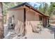 Exterior view of home featuring deck with seating, wood siding, and manicured yard at 28251 Shadow Mountain Dr, Conifer, CO 80433