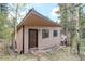 Exterior of cabin-style home with brown wood siding, surrounded by trees at 28251 Shadow Mountain Dr, Conifer, CO 80433