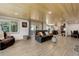 Bright, open-concept living area featuring wood paneling, stone fireplace, and outdoor views at 28251 Shadow Mountain Dr, Conifer, CO 80433