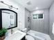 Modern bathroom with gray tiled walls, vanity with sink, bathtub, and stylish fixtures at 9411 Rose Ct, Thornton, CO 80229