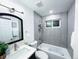 Modern bathroom with gray tiled walls, vanity with sink, bathtub, and stylish fixtures at 9411 Rose Ct, Thornton, CO 80229