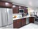 Updated kitchen with stainless steel appliances, ample counter space, and dark wood cabinetry at 9411 Rose Ct, Thornton, CO 80229