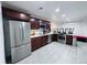 Spacious kitchen with stainless steel appliances, dark cabinets, and modern tile floors at 9411 Rose Ct, Thornton, CO 80229