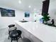 Modern kitchen island featuring sleek, white countertops, stylish stools, and minimalist decor at 9411 Rose Ct, Thornton, CO 80229