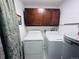 Functional laundry room with washer, dryer, and overhead cabinets for storage at 9411 Rose Ct, Thornton, CO 80229