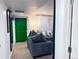A stylish living room with a modern gray sofa, a striking green door, and cozy lighting at 9411 Rose Ct, Thornton, CO 80229