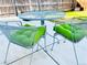 Outdoor patio set features a round metal table with two chairs, and bright green cushions at 9411 Rose Ct, Thornton, CO 80229